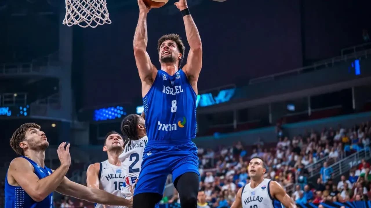 Jugador israelí anotando durante partido de baloncesto