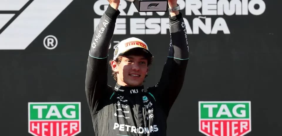 Piloto levantando trofeo en el podio de carrera