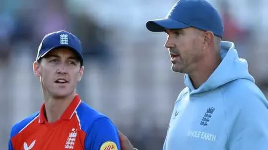 Entrenador hablando con jugador durante partido de cricket