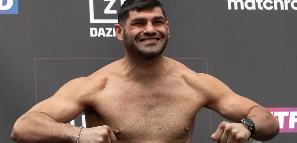 Luchador posando en pesaje con sonrisa amplia