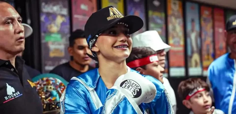 Boxeadora sonriendo con guantes antes de la pelea