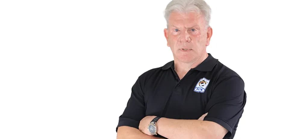 Entrenador de fútbol con brazos cruzados en uniforme