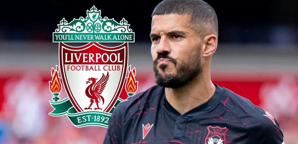 Jugador con camiseta negra frente al logo de Liverpool