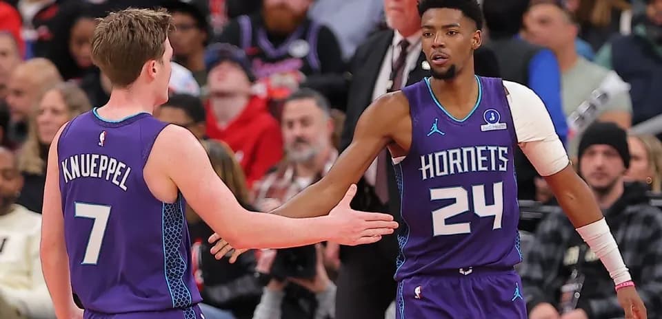 Jugadores de Hornets chocando las manos en el partido
