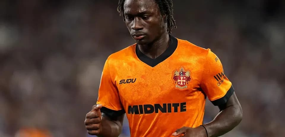 Jugador con camiseta naranja corriendo en el campo