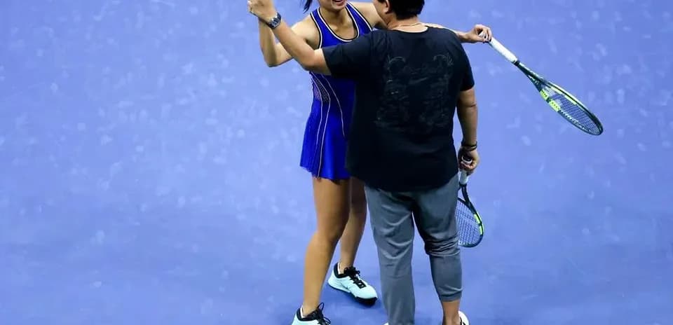 Jugadora de tenis celebrando con su entrenador en cancha