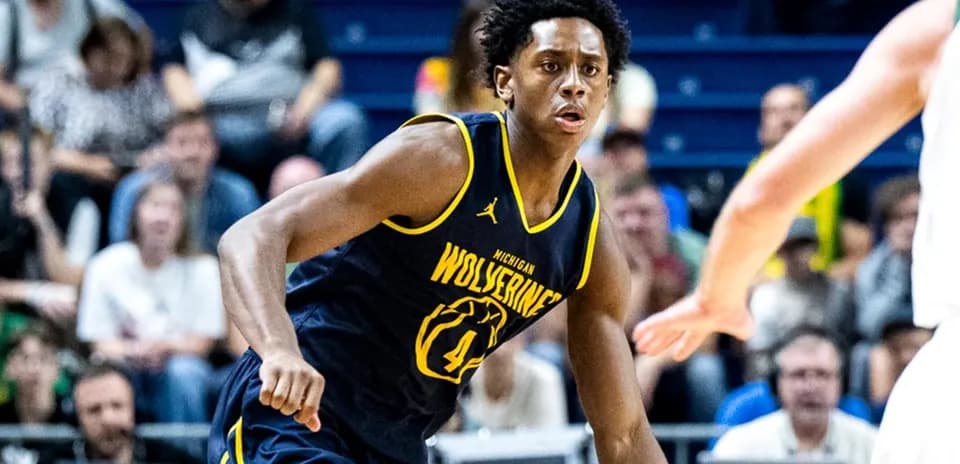 Jugador de baloncesto de Michigan driblando en partido