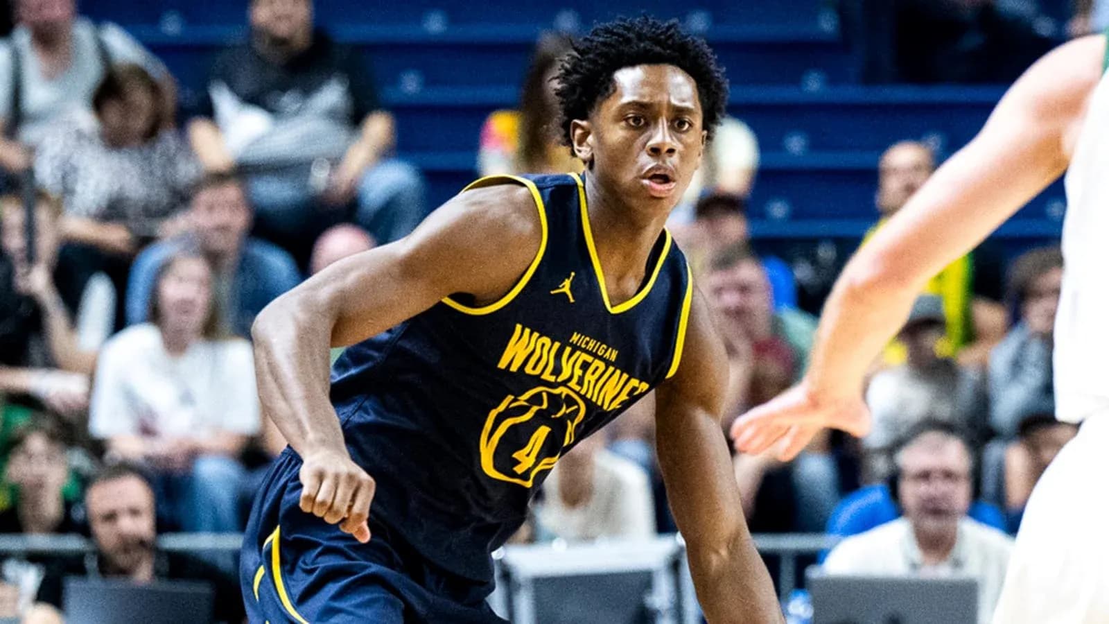 Jugador de baloncesto de Michigan driblando en partido