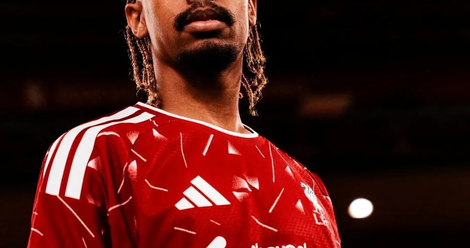 Jugador posando con camiseta roja de Liverpool