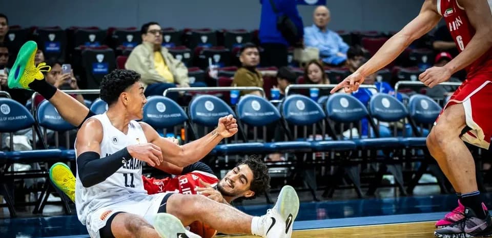 Jugadores en el suelo tras una jugada de baloncesto