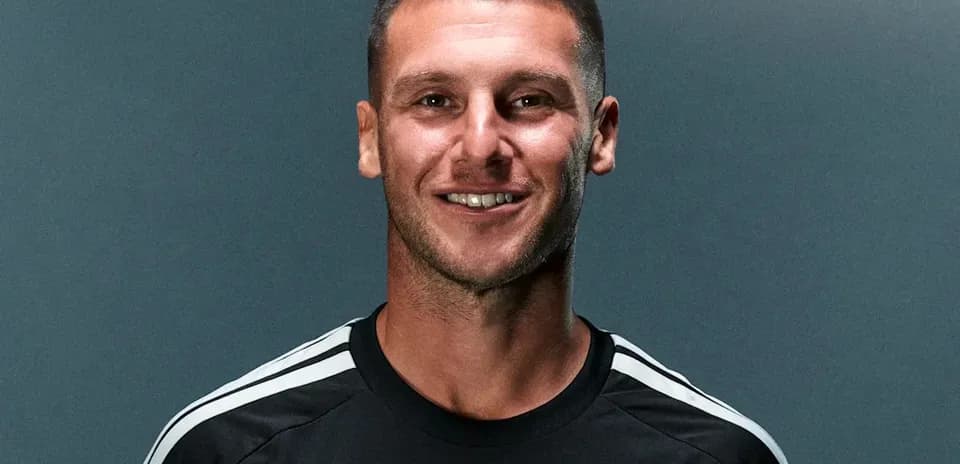 Jugador sonriente en camiseta negra con rayas blancas