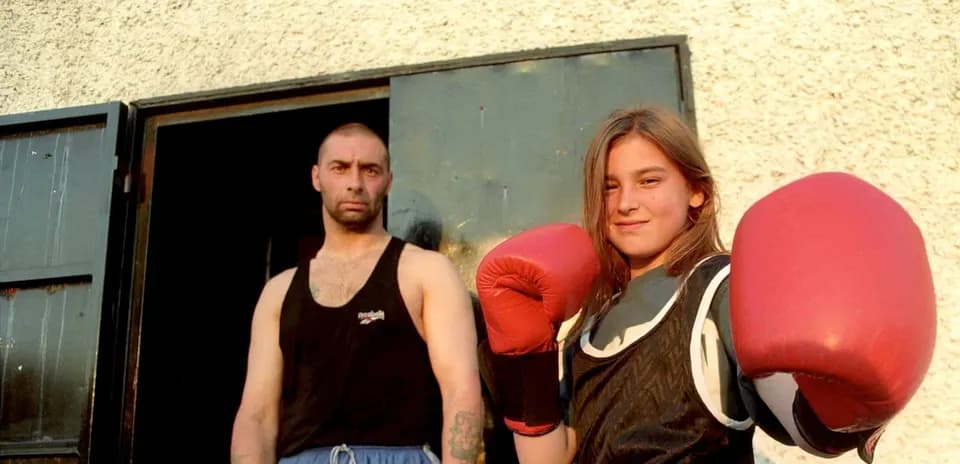 Joven boxeadora con guantes rojos y entrenador