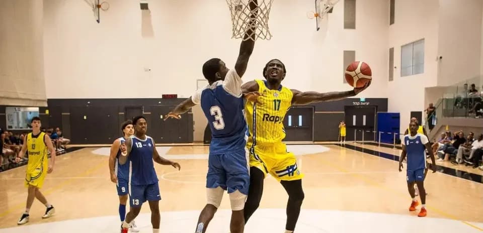 Jugador encestando mientras es defendido en baloncesto