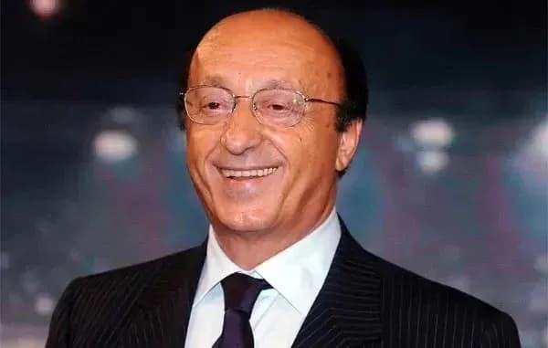 Hombre sonriente con gafas y traje oscuro