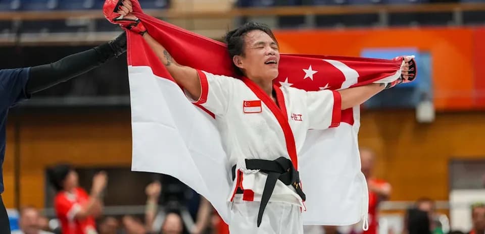 Atleta sosteniendo la bandera de Singapur en celebración