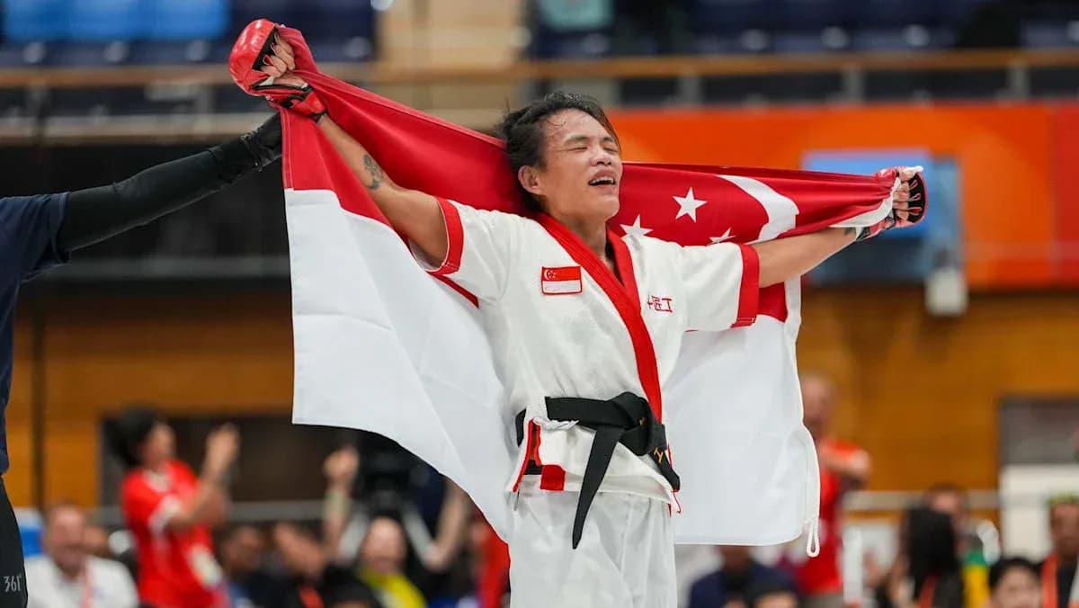 Atleta sosteniendo la bandera de Singapur en celebración