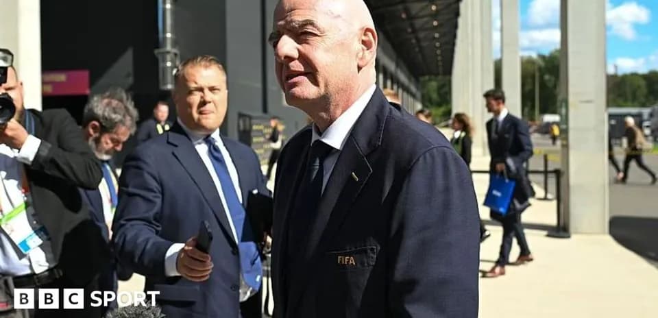 Hombre hablando con micrófono en evento de FIFA