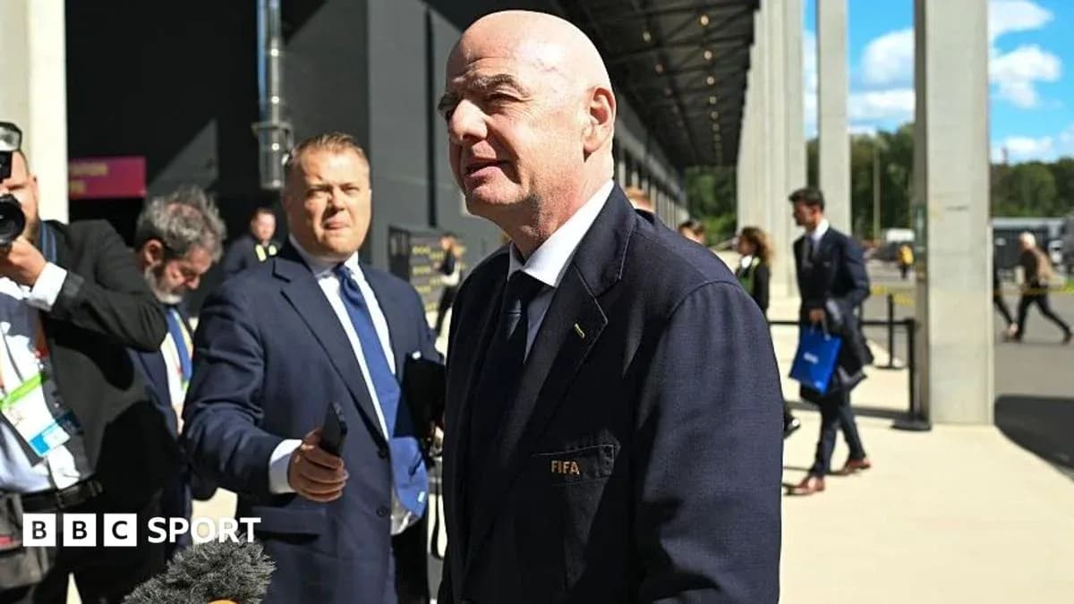 Hombre hablando con micrófono en evento de FIFA