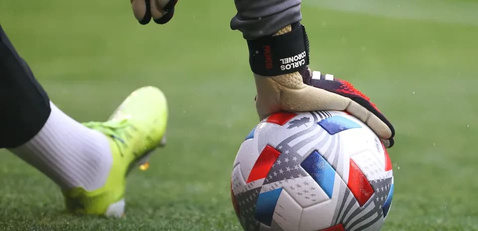 Portero sosteniendo el balón en el campo
