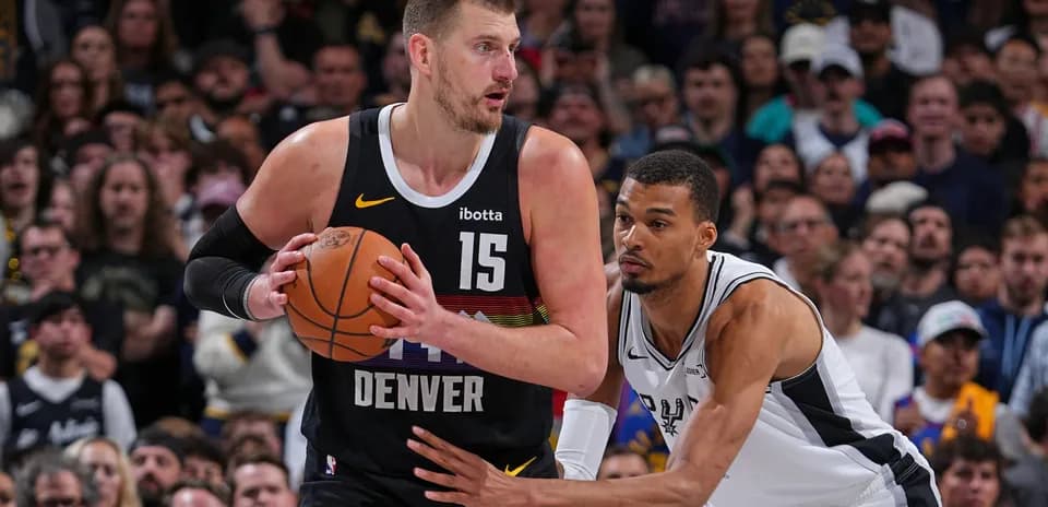 Jugador de Denver driblando mientras es defendido
