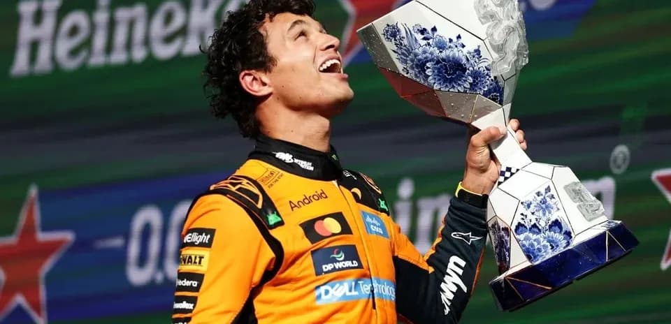 Piloto de Fórmula 1 sosteniendo trofeo en podio