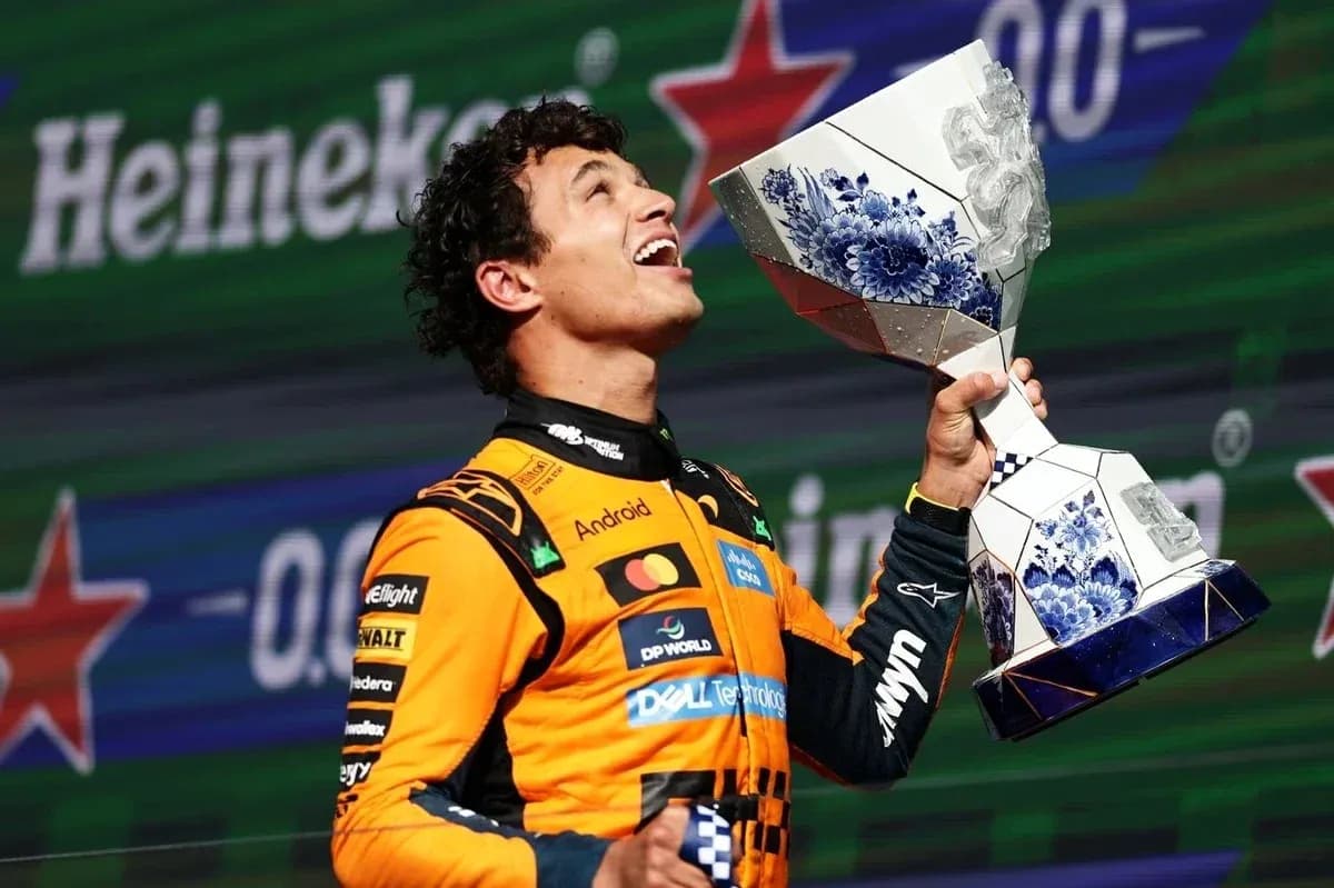 Piloto de Fórmula 1 sosteniendo trofeo en podio