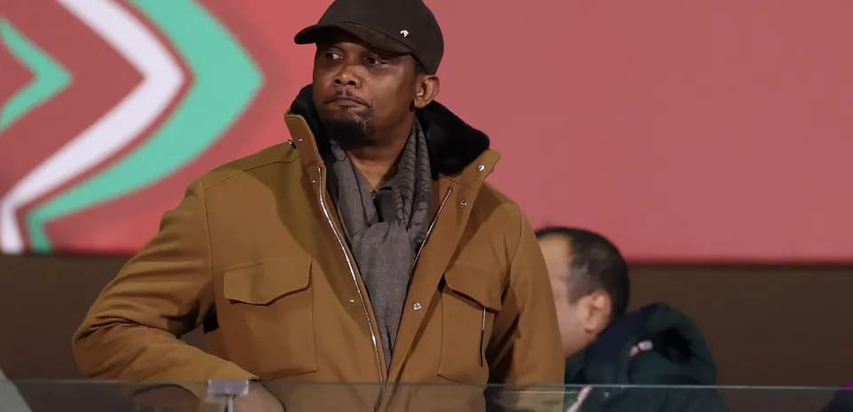 Hombre en abrigo observando un evento deportivo