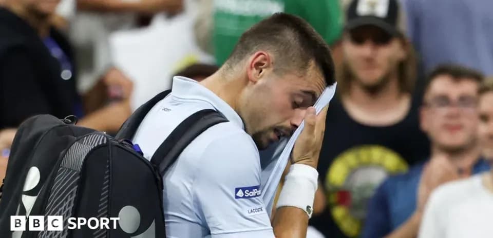 Jugador de tenis secándose la cara durante el partido