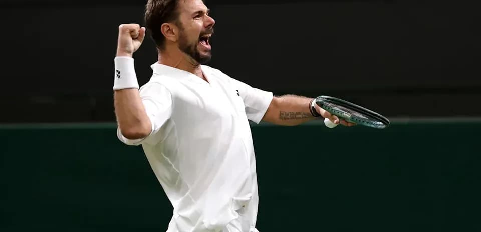 Jugador de tenis celebrando con raqueta en mano