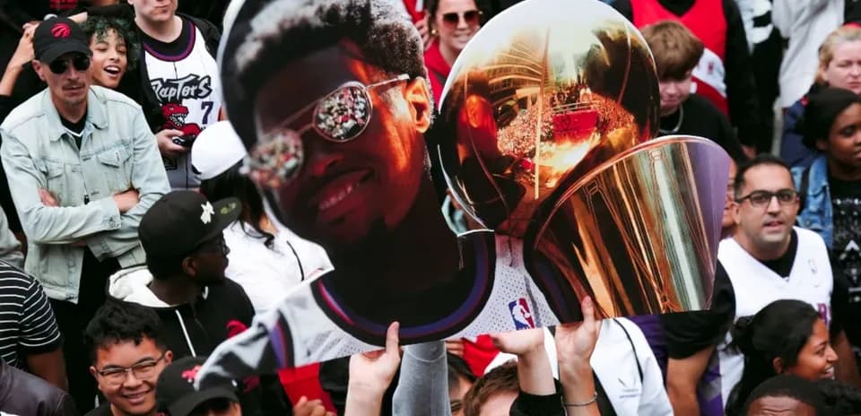 Fan holding a large cutout and trophy at celebration