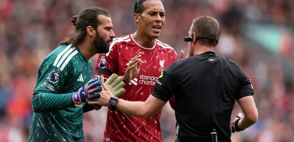 Alisson y Virgil van Dijk discutiendo con el árbitro