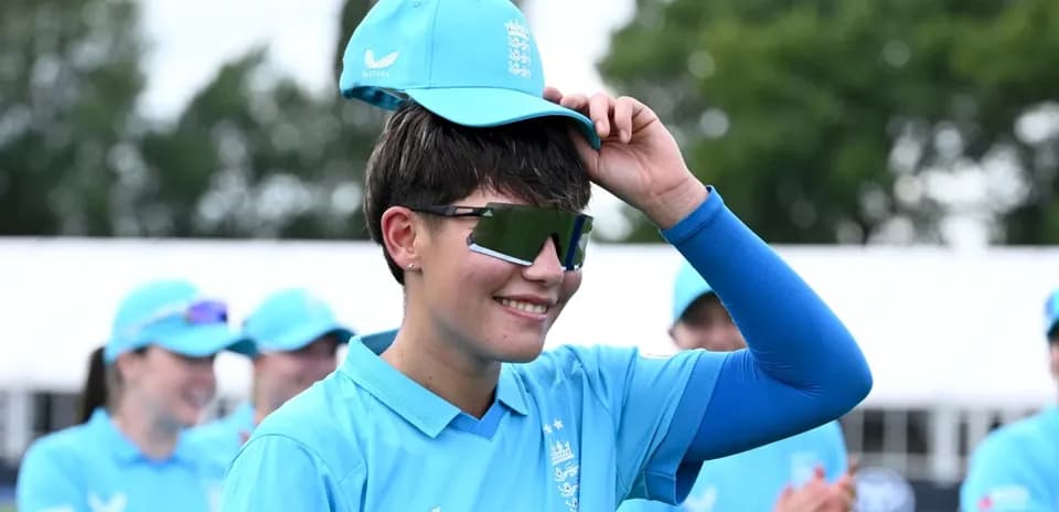 Jugadora de cricket con gorra y gafas de sol