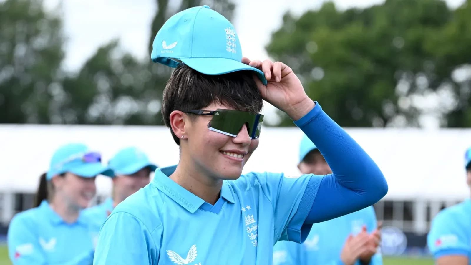 Jugadora de cricket con gorra y gafas de sol