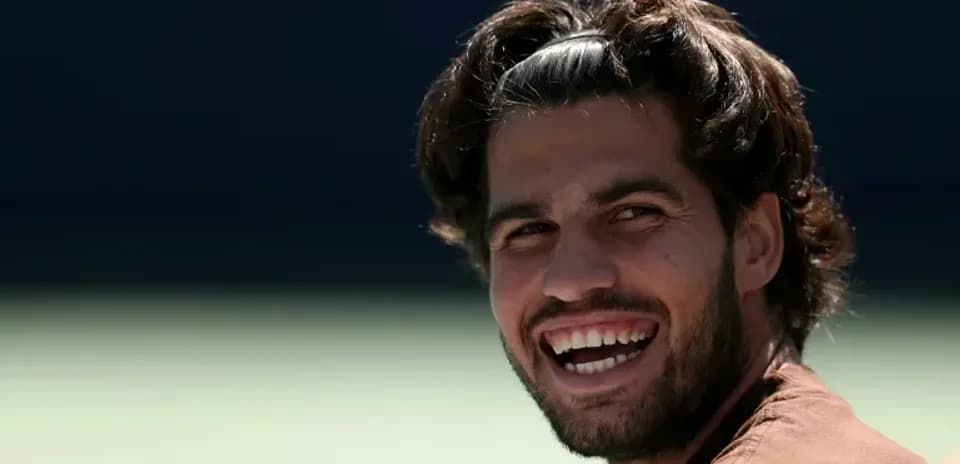 Jugador de tenis sonriendo en la cancha