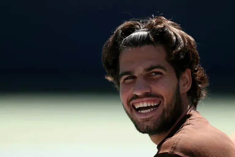 Jugador de tenis sonriendo en la cancha