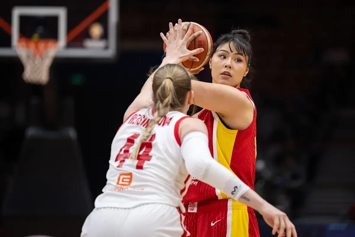 Jugadora lanzando el balón durante un partido de baloncesto