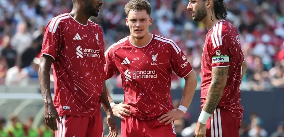 Tres jugadores de Liverpool conversando en el campo