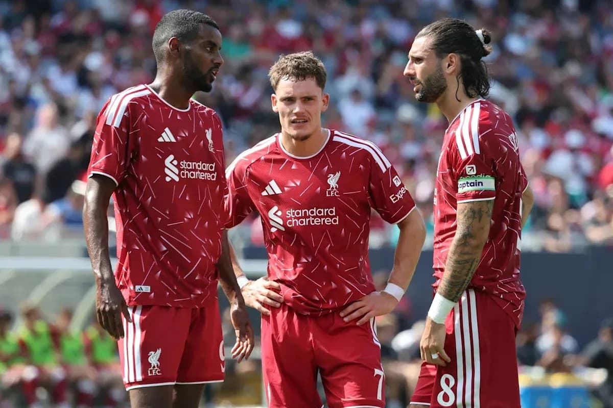 Tres jugadores de Liverpool conversando en el campo