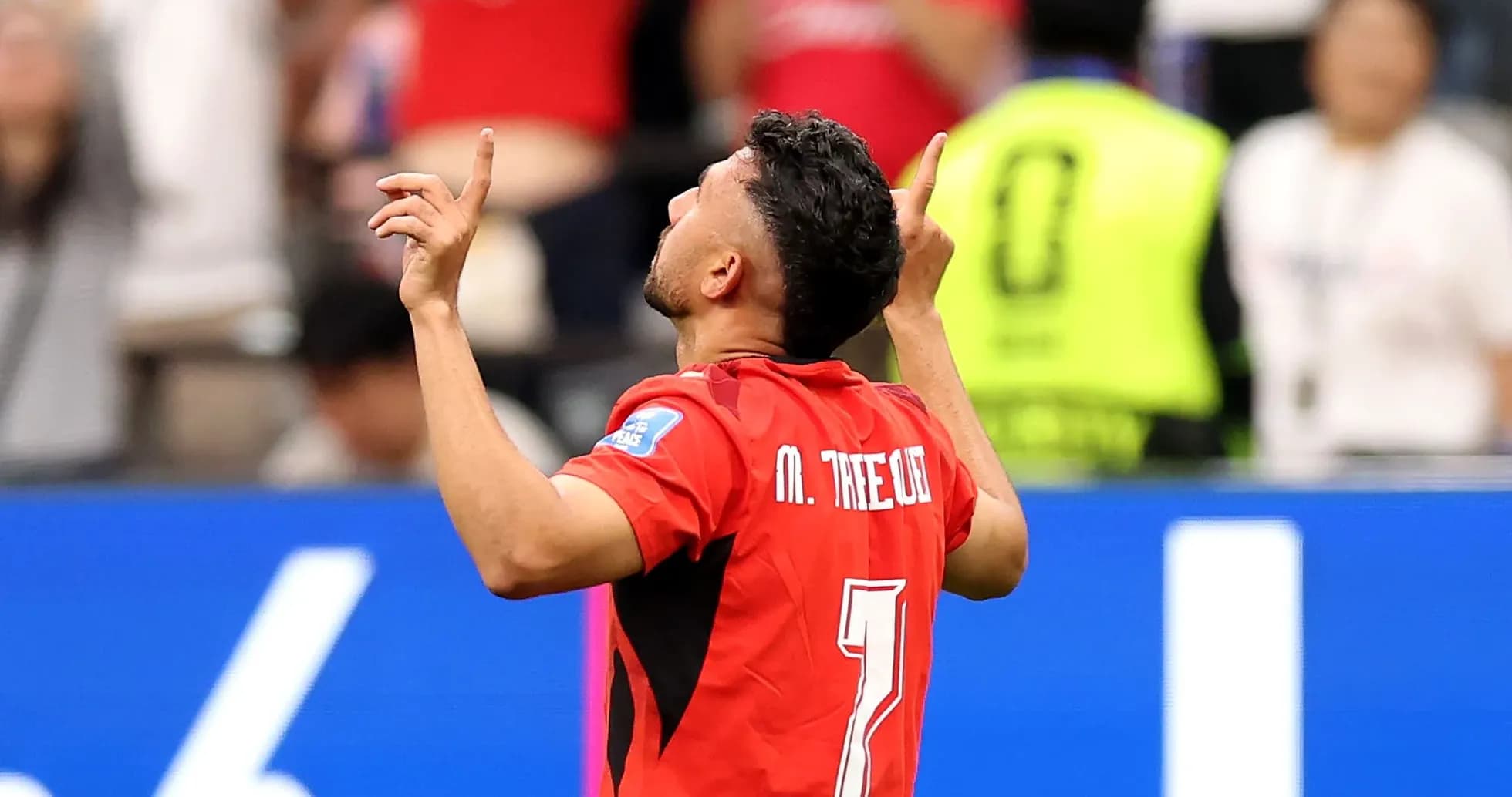 Jugador celebrando con manos al cielo en partido