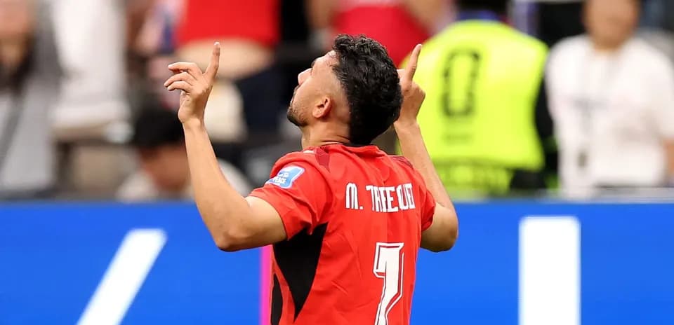 Jugador celebrando con manos al cielo en partido