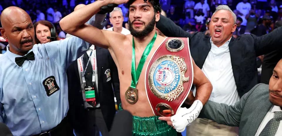 Boxeador sosteniendo cinturón de campeón tras victoria