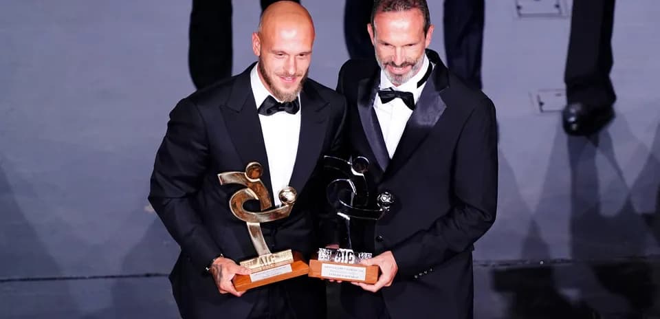 Dos hombres con trofeos en evento de premiación