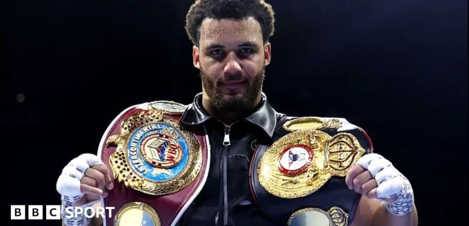 Boxeador sosteniendo dos cinturones de campeonato