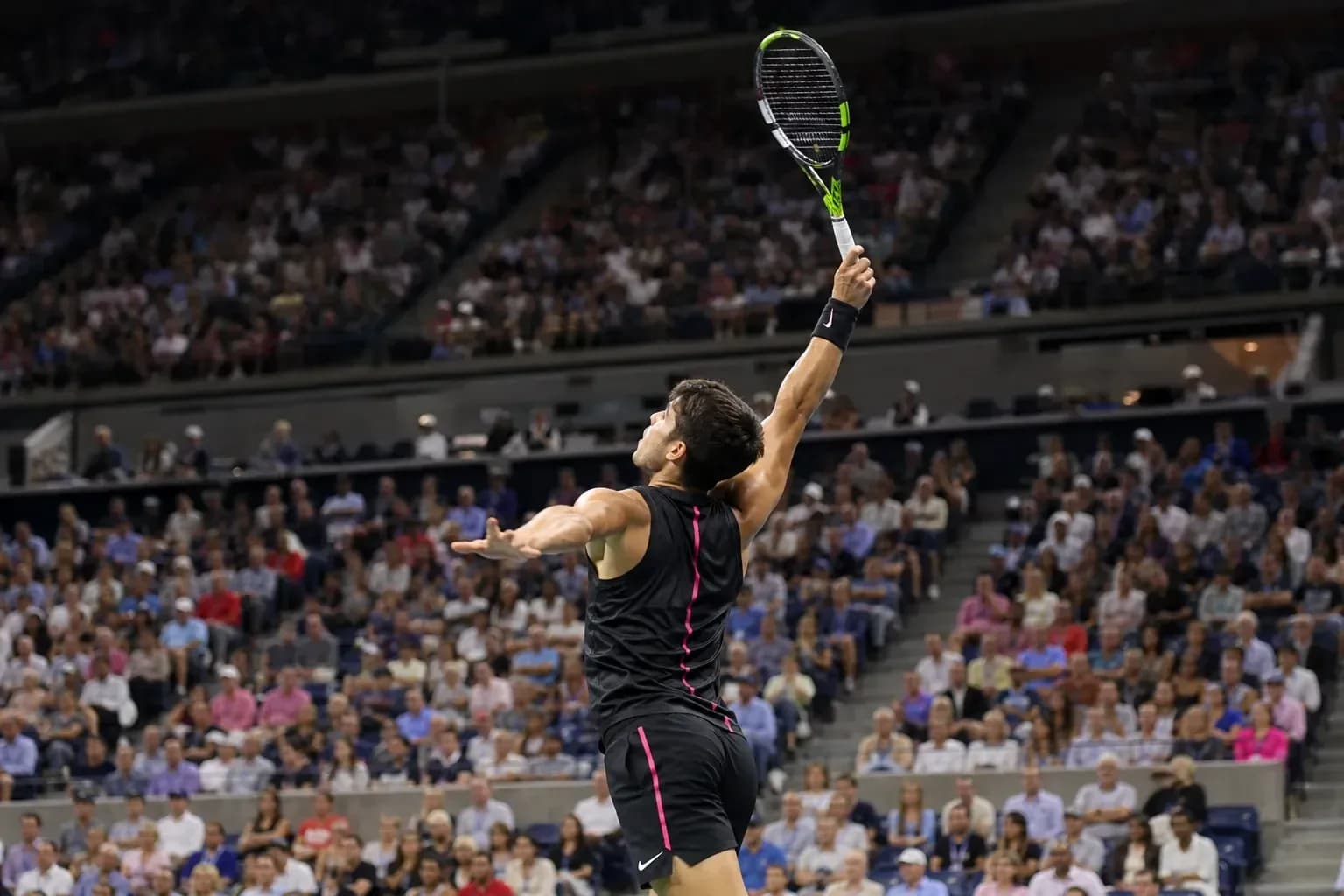Jugador de tenis sacando en un partido