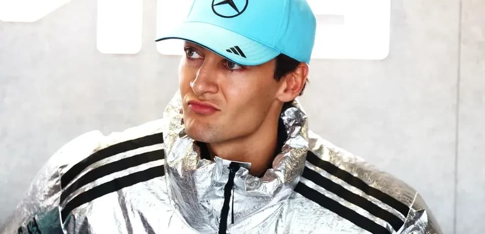 Piloto con chaqueta plateada y gorra azul