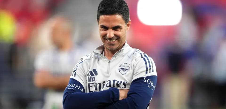 Entrenador de Arsenal sonriendo en el campo