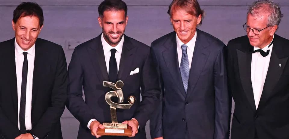Cuatro hombres posando con un trofeo en evento