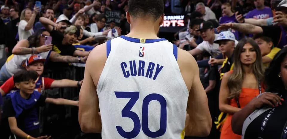 Jugador con camiseta de Curry rodeado de aficionados