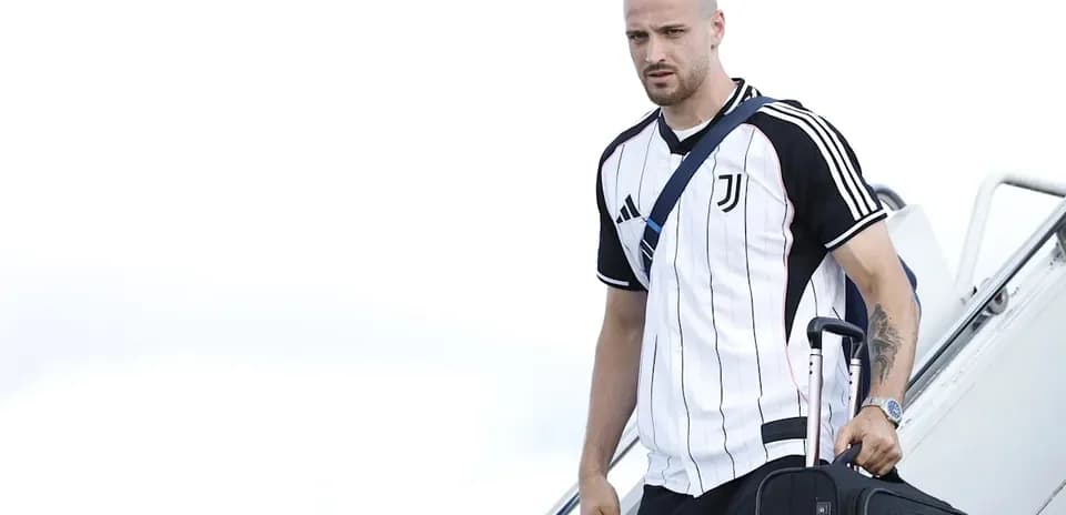 Jugador de Juventus bajando del avión con maleta