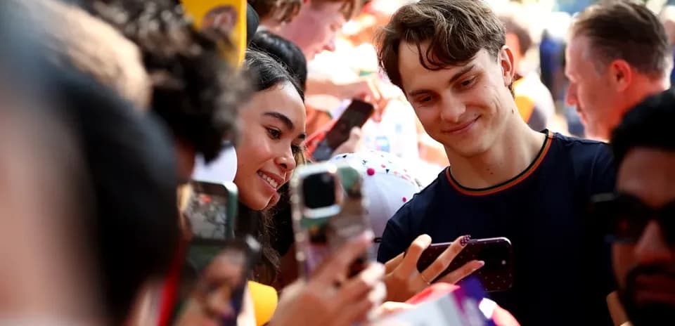 Joven y mujer tomando selfie entre la multitud